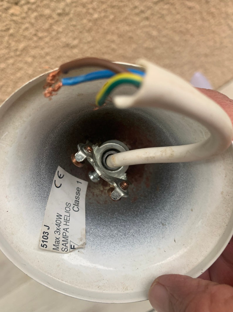 K&ouml;nnte beinhalten: Nahaufnahme einer wei&szlig;en Deckenleuchte mit einem wei&szlig;en Kabel und drei daran angeschlossenen Kabeln. Die Leuchte tr&auml;gt ein Etikett mit der Aufschrift "5103 J Max 3x40W SAMPA HELIOS Classe 1 CE".
