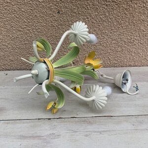 K&ouml;nnte beinhalten: Ein wei&szlig;er Metall-Kronleuchter mit gr&uuml;nen und gelben floralen Akzenten. Der Kronleuchter hat f&uuml;nf Gl&uuml;hbirnen und es fehlt eine der Gl&uuml;hbirnenabdeckungen.