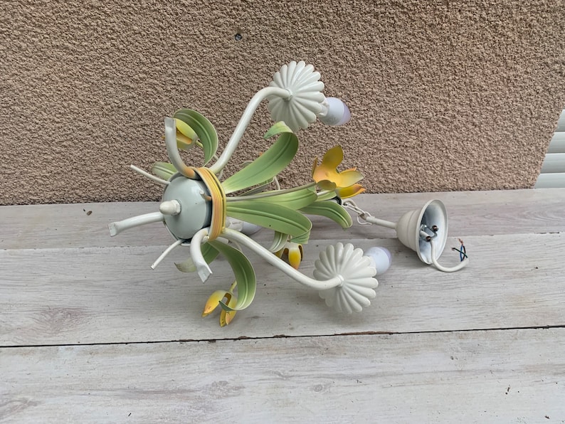 K&ouml;nnte beinhalten: Ein wei&szlig;er Metall-Kronleuchter mit gr&uuml;nen und gelben floralen Akzenten. Der Kronleuchter hat f&uuml;nf Gl&uuml;hbirnen und es fehlt eine der Gl&uuml;hbirnenabdeckungen.