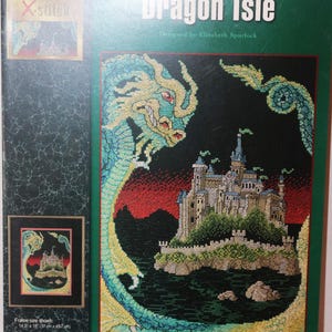 May include: A cross-stitch pattern leaflet titled "Dragon Isle" by Elizabeth Spurlock. The design features a castle on an island, surrounded by a dragon. The color palette includes green, blue, red, and beige. The leaflet includes frame size information in inches.