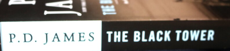 May include: A black and white book cover with the title "The Black Tower" and the author's name "P.D. James" in white text.