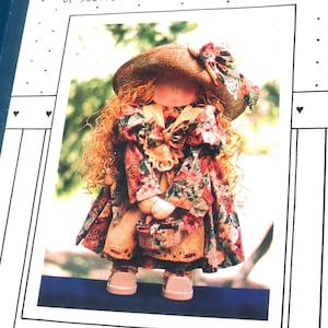 May include: A pattern for a 30-inch wood and cloth doll named Courtney. The doll is wearing a floral dress and a straw hat. The pattern is called "Sharin' a little bit" and is from Ben Franklin.