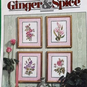 May include: A cross-stitch pattern booklet titled "Ginger & Spice" with the design name "Les Fleurs" and the number 9201. The booklet features four floral cross-stitch designs, each framed in a gold frame and displayed on a pink background. The designs include a bouquet of pink roses, a bouquet of white lilies, a bouquet of purple flowers, and a bouquet of pink roses.