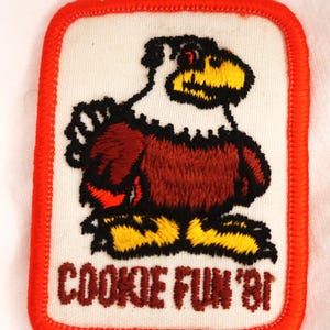 May include: A red, white, and brown embroidered patch with a cartoon eagle and the text "COOKIE FUN '81".
