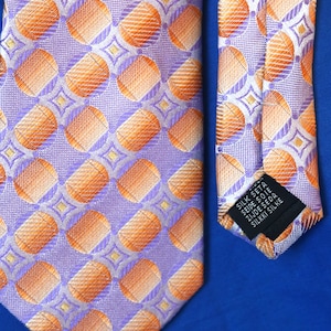 May include: A purple and orange patterned tie with a black label that reads "Silk Satin 100% Silk Made in Italy Silk Satin".