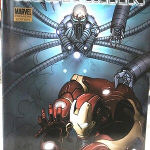 May include: Comic book cover featuring Iron Man in a red and gold suit, fighting a robotic figure with multiple arms. The cover text reads "The Invincible Iron Man" and "Unfixable".