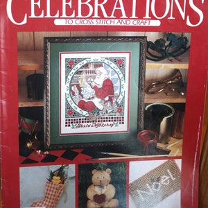 May include: A magazine cover for a cross stitch and craft publication called "Celebrations". The cover features a cross stitch design of Santa Claus in his workshop, a stocking filled with candy canes, a teddy bear with a heart, and a sign that says "Noel".