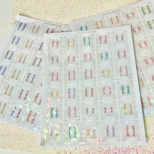 May include: A set of clear stickers with a holographic finish. The stickers feature various words, including "protection", "faith", "love", "truth", and "infinite".