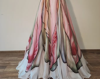 May include: A white halter-style dress with a flowing skirt featuring a colorful abstract floral print. The skirt is layered with a white chiffon overlay.