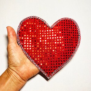 May include: Red heart-shaped sequin patch with a silver glitter trim.