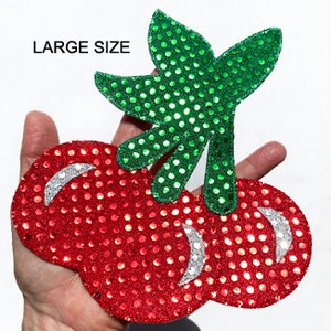 May include: Large red and green sequined cherry patch. The cherries are outlined in silver sequins. The stem and leaves are green sequins.