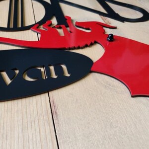 May include: Black and red metal wall decor with the words "Stark" and "House Stark" and a dragon design.