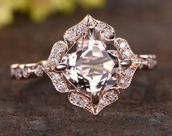 Könnte beinhalten: Verlobungsring aus Roségold mit einem Kissen-geschliffenen Morganit-Edelstein, umgeben von einem Halo aus kleineren Diamanten. Der Ring hat ein zartes, vintage-inspiriertes Design.
