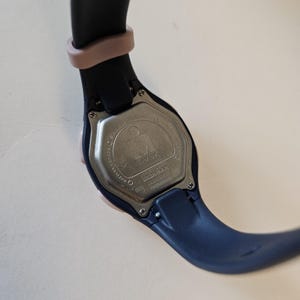 May include: A black and pink wristwatch with a silver face and the word "Timex" printed on it. The watch has a black band with a pink accent.