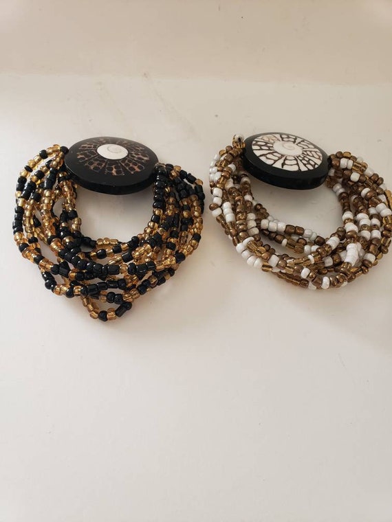 Two VINTAGE stretch black and gold and gold and wh