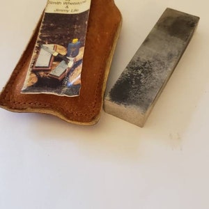 May include: A brown leather case with a sharpening stone inside. The case has a label that reads "Sharpening Made Easy by Smith Whetstone & Jimmy Like".