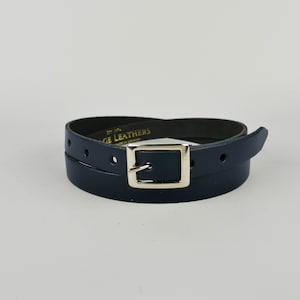 May include: A dark blue leather belt with a silver buckle. The belt is double-layered and has the text "Vintage Leathers" embossed on the leather.