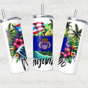 Puede incluir: Tres vasos de acero inoxidable blancos con tapas y pajitas. Cada vaso presenta un diseño diferente con un tema tropical. Un vaso tiene una rana verde en una bandera azul y blanca, otro tiene una palmera y flores, y el tercero tiene una ola y flores.