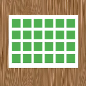 May include: A white rectangular paper with a grid of 24 green squares. The paper is set against a wooden background with a brown wood grain pattern.