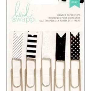 May include: Set of five black and white patterned paper clips. The clips are shaped like banners and have a silver finish. The patterns include stripes, polka dots, and a white glitter design. The package includes the text "Banner Paper Clips" and "leiki swapp".