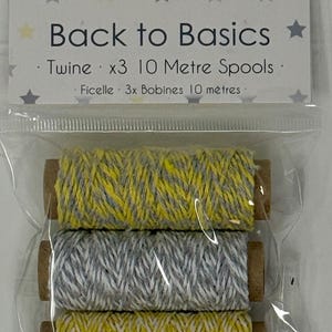 May include: A clear plastic package containing three spools of twine, each 10 meters long. The top and bottom spools feature yellow and white twisted twine, while the middle spool features gray and white twisted twine. The header card reads Dovecraft Baby Steps Back to Basics Twine x3 10 Metre Spools.