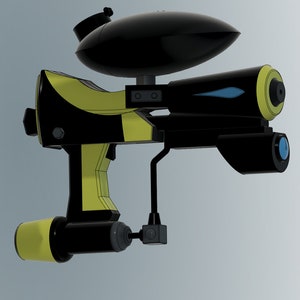 Puede incluir: Una pistola de paintball negra y amarilla con un dep&oacute;sito negro en la parte superior. La pistola tiene un ca&ntilde;&oacute;n azul y una empu&ntilde;adura negra y amarilla.