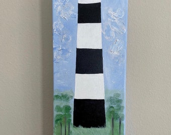 May include: A painting of a black and white striped lighthouse with a blue sky and green trees in the background. There are blue flowers in the foreground.