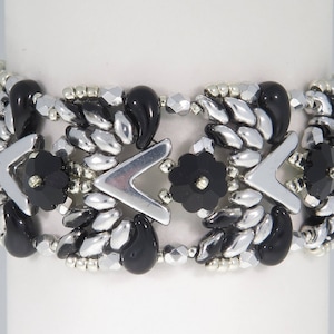 May include: A silver and black beaded bracelet with a geometric design. The bracelet features black beads, silver beads, and silver metal accents.