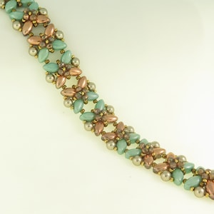 Może przedstawiać: Bransoletka z zielonych i miedzianych koralików z kwiatowym wzorem. Bransoletka wykonana jest z małych, okrągłych koralików i ma zapięcie.