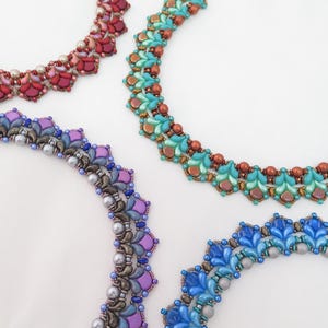 May include: Four beaded necklaces arranged in a circular pattern. Each necklace features intricate woven patterns using small glass beads in various colours including red, teal, purple, and blue, accented with metallic and pearl-like spherical beads.