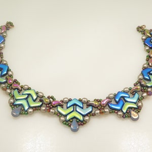 May include: A multi-strand necklace featuring iridescent blue, green, and silver beads in a chevron design.