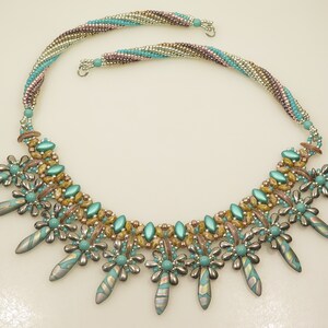 Peut inclure: Un collier de perles turquoise et or avec une cha&icirc;ne multi-brins et un pendentif d&eacute;coratif compos&eacute; de perles turquoise et argent.