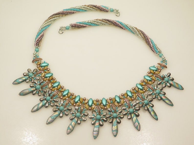 Peut inclure: Un collier de perles turquoise et or avec une cha&icirc;ne multi-brins et un pendentif d&eacute;coratif compos&eacute; de perles turquoise et argent.