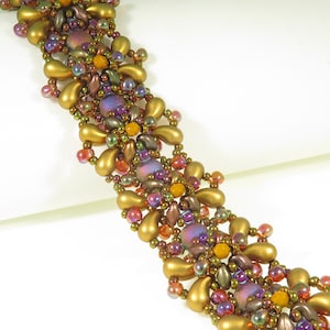 May include: An intricate beaded bracelet in gold, purple, orange, and red. The design incorporates teardrop-shaped beads and smaller beads, creating a detailed pattern. The bracelet's design is ornate and visually striking.