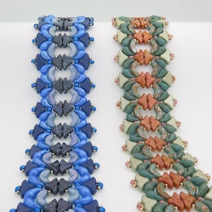 May include: Two beaded bracelets, one in shades of blue and the other in shades of green, brown, and orange. The bracelets are made with small, faceted beads and have a geometric pattern.