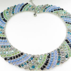 May include: A multi-coloured beaded necklace with a silver clasp. The necklace is made with blue, green, black, and silver beads.