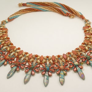 Peut inclure: Un collier multi-rangs de perles avec un motif g&eacute;om&eacute;trique. Le collier pr&eacute;sente une vari&eacute;t&eacute; de perles dans des tons de brun, orange et turquoise. Les perles sont dispos&eacute;es en un motif de fleurs et de pointes.