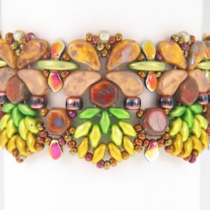 Può includere: Un braccialetto di perline con un design multicolore che presenta perline marroni, verdi, gialle e arancioni. Il braccialetto ha un motivo geometrico con un motivo floreale.