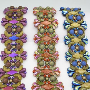 May include: Three beaded bracelets with intricate patterns in shades of purple, orange, and blue. The bracelets are made with seed beads, bugle beads, and other decorative beads.