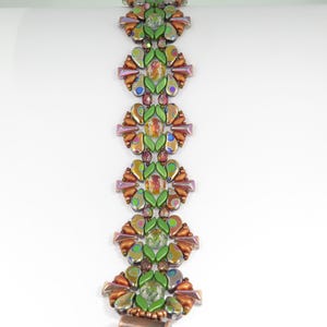 Peut inclure: Un bracelet en perles vert, marron et violet avec un motif géométrique.