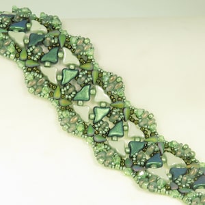May include: A green and white beaded bracelet with a wavy design. The bracelet is made with small, round beads and larger, triangular beads.
