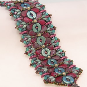 May include: A beaded bracelet featuring a floral design. The bracelet is made with red, green and gold beads.