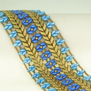 May include: A beaded bracelet featuring a repeating pattern of gold-colored leaf-shaped beads and light blue flower-shaped beads. The bracelet is approximately 1.5 inches wide and has a delicate, intricate design. The beads are strung together with thin, gold-colored strands.
