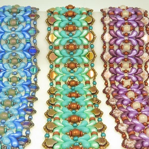 May include: Three beaded bracelets with intricate patterns. The bracelets are made with blue, green, and purple beads. The beads are arranged in a repeating pattern of flowers and teardrops.