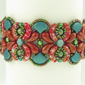 Op de afbeelding: Een kralenarmband met een geometrisch patroon in tinten rood, groen en blauw. De armband is gemaakt met kleine, ronde kralen en grotere, onregelmatig gevormde kralen.