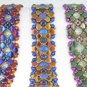 May include: Three beaded bracelets with intricate patterns in shades of blue, gold, and green. The bracelets are made with small, round beads and feature a unique, geometric design.