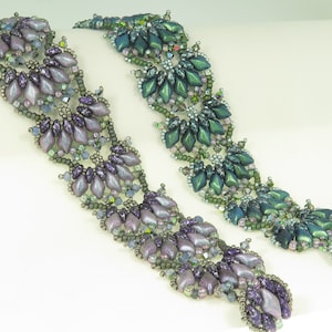 Puede incluir: Dos pulseras de cuentas, una en tonos morados y la otra en tonos verdes. Ambas pulseras presentan un patrón repetitivo de pequeñas cuentas en forma de lágrima.