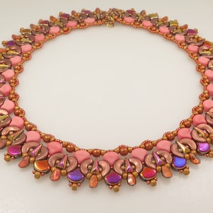 May include: A pink, brown and gold beaded necklace with a geometric design. The necklace is made of small, round beads and has a delicate, feminine look.