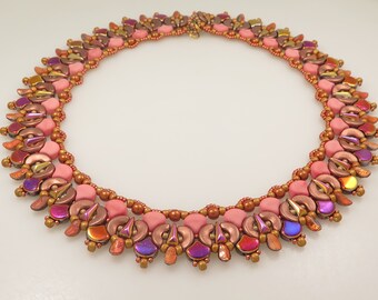 May include: A pink, brown, and gold beaded necklace with a geometric design. The necklace is made of small, round beads and has a delicate, feminine look.