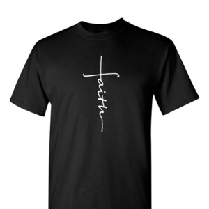 May include: Black t-shirt with a white script cross design. The word "faith" is written vertically within the cross. The shirt has a crew neck and short sleeves.